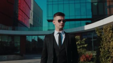 Profesyonel bir yönetici, şık bir işadamı, şehir yolunda yürüyüşünün tadını çıkarıyor, kentsel yeteneğini gösteriyor. Genç Erkek Girişimci Keyifli Yürüyüşe Çıkıyor