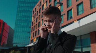 Duygusal ifadenin dokunaklı bir sahnesinde, beyaz yakalı bir adam düşüncelerini ve duygularını akıllı telefonuyla şehrin hareketli arka planında tartışır..