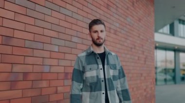 Şehirde zarif sakallı bir adam var. Şehirde kameraya bakan zarif sakallı bir adamın portresi.