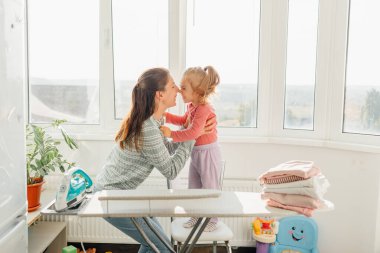 Samimi Aşk ve Kahkahalar Mutlu Anne ve Kız Eğlenceli Ev Çalışmalarının, Aile Yaşamının Gerçek Özünü Yakalayışının keyfini çıkarıyorlar. Gerçek Annelik Otantik Aile Oyunculuğu Kucaklar