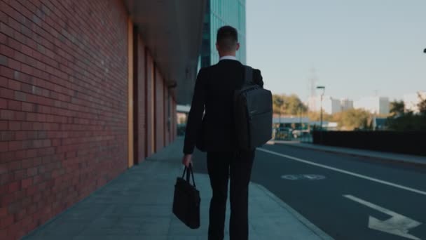 成功した起業家 スーツの若いラテン人 街のエネルギーに囲まれたアウトドアを散策し バッグを運ぶ — ストック動画