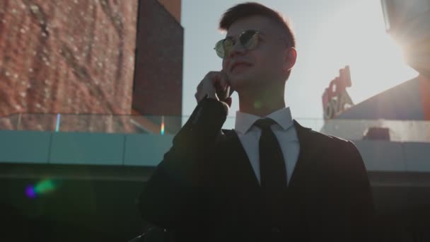Ung Affärsman Klädd Kostym Aktivt Deltar Ett Samtal Sin Smartphone — Stockvideo