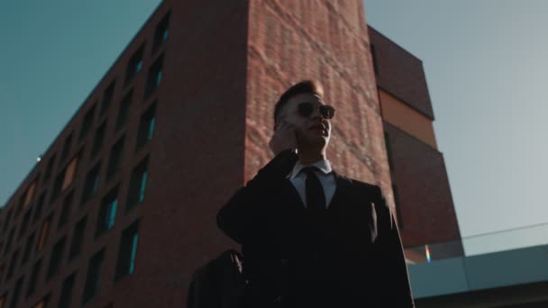 Şehir Siluetinin Arka Planında Takım Elbiseli Genç Bir Adam Akıllı — Stok video