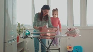 Evim Güzel Ev Üç Kişilik Bir Aile, Anne, Kız ve Çocuk, Ev Temizliği ve Ev İşleri ile meşguller. Ev işi, anne, kız ve ütü.