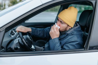 Grip mevsiminin acı gerçekleriyle yüzleşen sakallı bir şoförle şehrin sokaklarında dolaş. Bu canlı görüntü, şehrin sokaklarında hapşıran ve öksüren genç adamların mücadelesini yakalıyor..