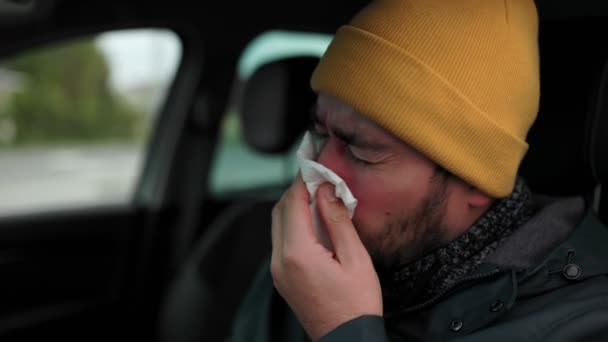 インフルエンザに苦しむ病気の運転手の人生にステップ この詳細な写真は 若い男がドライバーの座席にくしゃみをし 市街地の病気の現実を伝えることを示しています — ストック動画