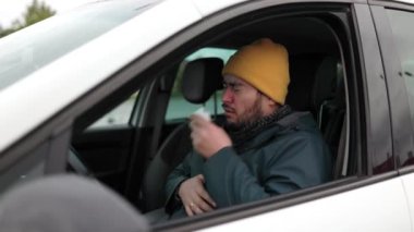 Bir şehrin, kötü durumdaki bir sürücünün, mevsimsel bir hastalığın ortasında hapşırması ve öksürmesi lensi ile gidip gelişini tecrübe edin. Bu canlı görüntü genç sakallı bir şoförün dayanıklılığını yansıtıyor.