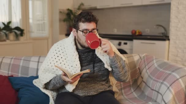 Cold Comfort Male Figure Eyeglasses Sips Medicine Mug While Reading — 비디오