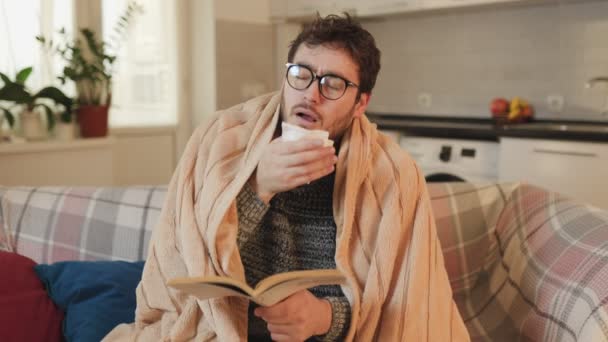 眼镜中的冷而不健康的男性形象 被遮掩 从事阅读和在家打喷嚏 舒适的流感征战男读者与眼镜 导航通过咳嗽和打喷嚏 — 图库视频影像