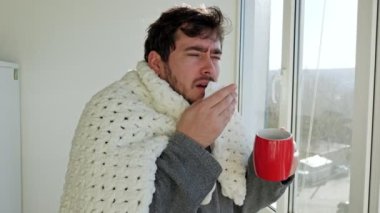 Kafkas kökenli stresli genç bir adam, bir yorgana sarılmış, griple mücadele ediyor. Evinin penceresinin yanında hapşırır ya da öksürerek mevsimsel hastalığın gerçek bir temsilcisi olur..