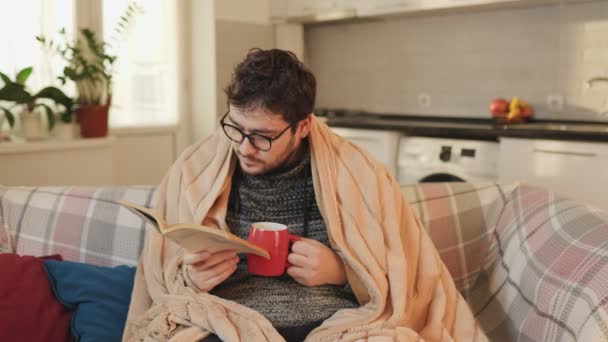 インフルエンザシーズン 無熱のアパート メガネの男性とセッティング 医学と読書 温かい 飲み物 リラックス — ストック動画