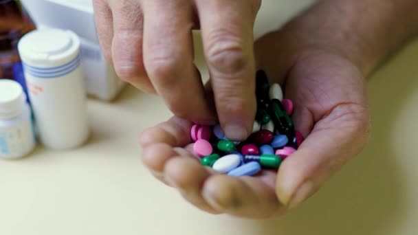 无法辨认的手拿着一把药丸 另一只手拿着一片 超剂量的 在药罐的背景下医学的概念 想健康的愿望 — 图库视频影像