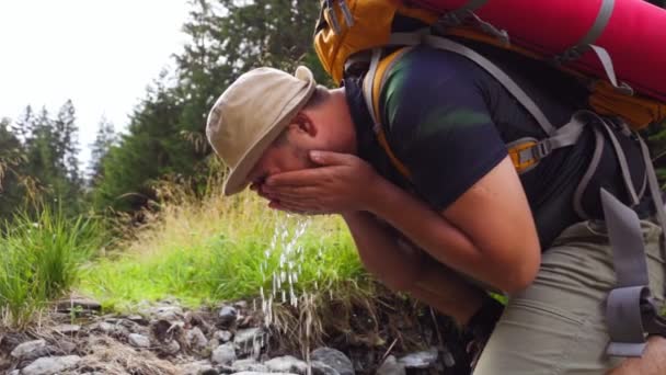 Młody Człowiek Myje Twarz Wodą Rzeczną Podczas Wędrówki Pieszej Natura — Wideo stockowe