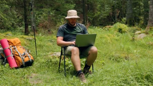 走进一个拉丁旅行者在森林探险迷人的背景下拥抱远程工作自由的世界 那个带着手提电脑徒步旅行的年轻人 — 图库视频影像