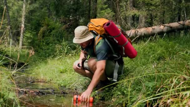 水合和谐的拉丁旅行者人解渴了 在一次风景如画的远足中 用清澈的河水灌满了一壶水 — 图库视频影像