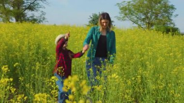 Mutlu çiftçi ailesi yazın el ele tutuşarak anne ve kızını gezdirir. Takım çalışması. Aile hafta sonu, kızıyla gülümseyen anne.