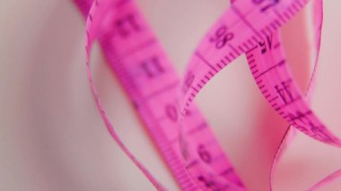 Bu yakın çekim videosunda kesinliği keşfet, bir dönme ölçüm bandını esnek bir metreyle göster. İzole edilmiş santimetre ölçeği, gelişim için mükemmel olan tek bir nesneyi vurguluyor