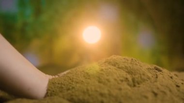 İnsan eli, parmak uçlarında seçici bir odak noktası olan verimli topraklarla dolu bir malayı tutar.