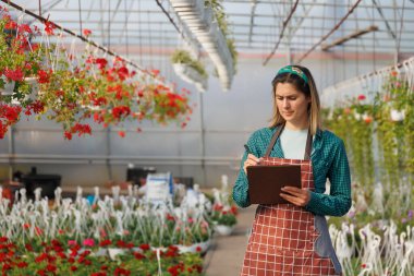 Kafkas kadın renk çiçeklerinin verilerini analiz etmek ve kaydetmek için serada deney yapmak için defter kullanıyor. Amerikan tarım mühendisi seradaki santralleri teftiş ediyor, uzayı kopyalıyor.