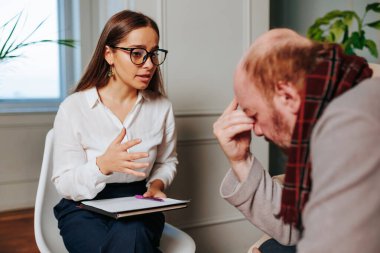 Depresif durumdaki yaşlı bir adam psikoterapist ve psikologdan destek istiyor. Psikolog genç kadın yaşlılara yardım eder. Yaşlılık, insan hayatı..