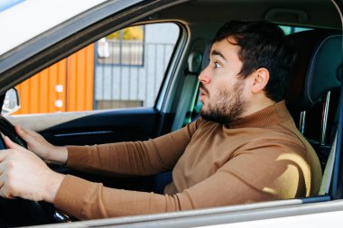 Oh, arabadaki genç adam mutlu bir şekilde bağırıyor gözleri açık ve uzaklığa bakıyor. Orta yaşlı bir adam ilginç bir şey gördüğünde gerçek duygularını gösterir. Şaşkınlık.