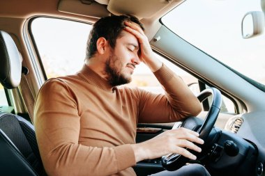 Yorgun genç adam dinlenmek için durdu, belki başı ağrıyordur. Belki hayatta bir şeyler oldu ve anılar canlandı. Yaşam konsepti.