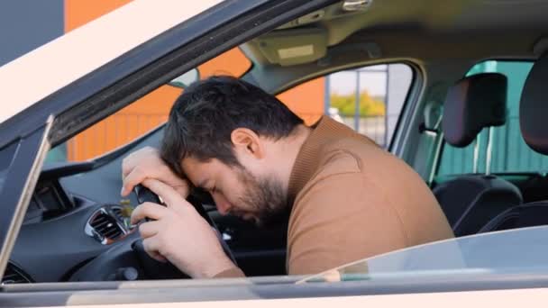 疲倦的年轻司机把头靠在方向盘上 精疲力竭 厌倦了过度劳累的概念 白种人开车时偏头痛 — 图库视频影像