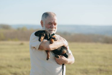 Alacakaranlığın yumuşak parıltısında, yaşlı bir beyefendi ve dachshund yoldaşı huzur ve neşe bulurlar..
