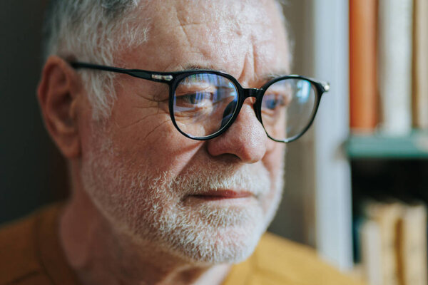 With an aura of scholarly authority, a senior gentleman, adorned with glasses and a beard, commands attention in the bookstore, embodying the essence of lifelong education.