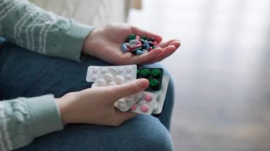 Evdeki tanınmayan kişilerin elindeki hapları kapatın. Enzimler, ağrı kesiciler, ağrı kesiciler. İnsanlar hastalanır ve tedavi edilirler. Vitaminler, mineraller, biyolojik takviyeler..