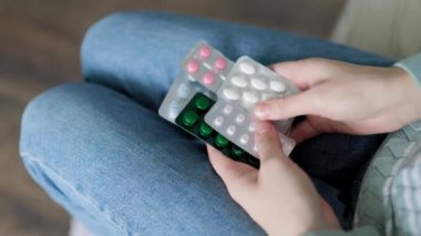 Evdeki tanınmayan kişilerin elindeki hapları kapatın. Enzimler, ağrı kesiciler, ağrı kesiciler. İnsanlar hastalanır ve tedavi edilirler. Vitaminler, mineraller, biyolojik takviyeler..