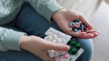 Evdeki tanınmayan kişilerin elindeki hapları kapatın. Enzimler, ağrı kesiciler, ağrı kesiciler. İnsanlar hastalanır ve tedavi edilirler. Vitaminler, mineraller, biyolojik takviyeler..