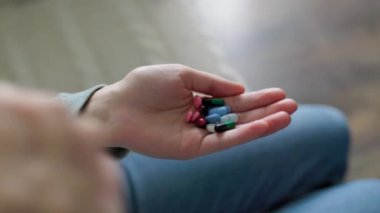 Evdeki tanınmayan kişilerin elindeki hapları kapatın. Enzimler, ağrı kesiciler, ağrı kesiciler. İnsanlar hastalanır ve tedavi edilirler. Vitaminler, mineraller, biyolojik takviyeler..