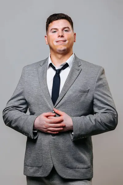 stock image Front view looking at camera young man with vitiligo disease with symmetrical spots on his face. A proud look and love for life characterize strong people. Gray background studio shot business suit.