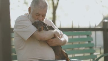 Etrafı güzelliklerle çevrili yaşlı bir beyefendi ve sadık dachshund yoldaşı özel arkadaşlıklarının keyfini çıkarıyorlar..
