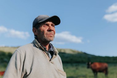 Kırsal arazinin arka planında, bu portre yaşlı bir köylü çiftçiyi özetliyor, şapkası ve yıpranmış yüz hatlarıyla hayatı ve açık hava çalışmaları hakkında konuşuyor..