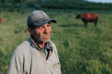 Portre, kıdemli çoban çiftçisinin dünyasına bir bakış sunuyor, yıpranmış yüzü ve azimli ifadesi, kırsal kesimin doğal güzelliğinde bir ömür süren emek ve emeği yansıtıyor..