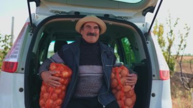 Başarı Çuvalı Yaşlı çiftçi hasat mevsiminde arabanın yanında dinleniyor..