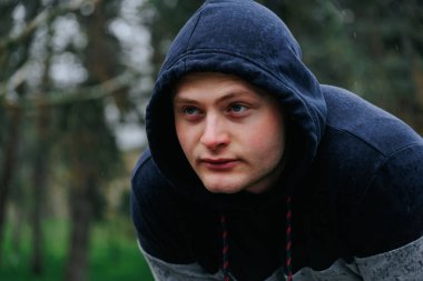 Bir erkek sporcunun ilham verici bir portresi, gücünü ve kararlılığını gözler önüne seriyor ve kameraya poz veriyor..
