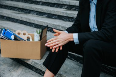 İşsizlik ve işsizliğin acı gerçekliğinin güçlü bir görüntüsü. Bir karton kutuyu tutan bir çift el. Kriz Kadını 'nın Ellerinde Kayıp Çalışmanın Kalıntılarını Tutun