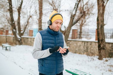 A candid shot of a man, running with headphones on and a smartphone in hand, embracing technology as part of his healthy lifestyle. showcasing the mental and physical benefits of a healthy lifestyle.