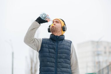 Alone and Active A man takes on the winter weather alone, while drinking water. He is a dedicated athlete, staying true to his healthy lifestyle and training even in the harsh wintertime conditions.