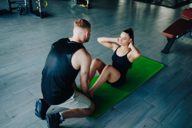 Motive olmuş bir kadın yoğun fitness eğitimi sırasında erkek bir antrenörden uzman eğitimi ve yardım alır. Kişisel antrenörlerin kendilerini adamaları ve dönüştürücü güçleri.