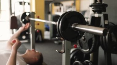 Halterle sıkı bir antrenman yapan aktif bir adam spor salonundaki fitness hedeflerine ulaşmak için limitlerini zorluyor. Fiziksel Fitness için Halterle Güç ve Hassas Yoğunluk Eğitimi
