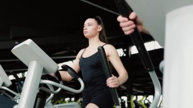 Spor salonunda sağlıklı bir yaşam tarzını kucaklayan zinde ve fevkalade bir genç kadın. Bir jimnastik sırasında kendine güvenen güçlü ve güçlü bir genç kadın.