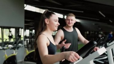 Güçlendirilmiş Eğitim Genç bir kadın spor salonundaki erkek kişisel antrenörden uzman rehberliği ve teşvik alır. Erkek Kişisel Eğitimcilerden Genç Kadın Yararları Uzmanlığı