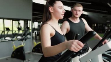Dinamik Fitness İkili A kendini adamış bir erkek antrenör spor salonundaki genç bir bayana yardım ve motivasyon eder. Eğitmen Rehberliği Erkek Kişisel Eğitmen Genç Kadın Spor Salonunda Excel Yardım Ediyor