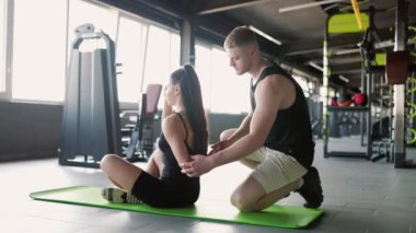 Terapötik Destek Erkek Terapisti, Spor Salonundaki Kadınların Sırt Ağrısına Yardım Ediyor. Bir erkek fizyoterapi seansında bir kadına spor yapma hedeflerinde yardım ediyor.