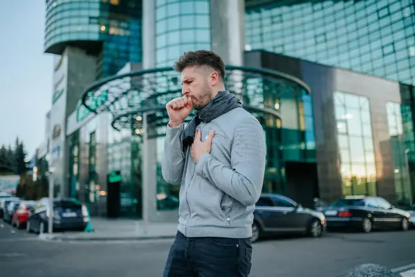 stock image Visualizing a young bearded Hispanic American man flu battle on the city streets, where sneezes and coughs express the discomfort of seasonal illness.