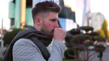 Genç adam öksürüyor, şehirde hapşırıyor. 